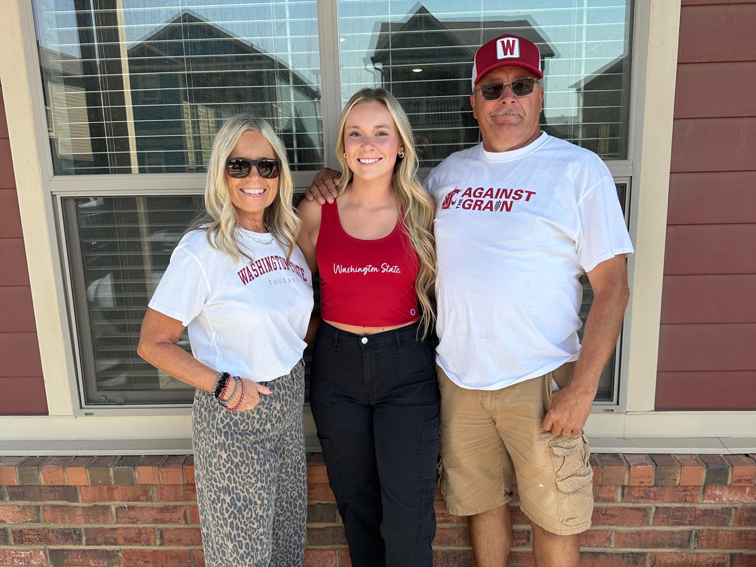 Three people in Washington State apparel outdoors